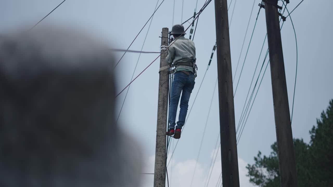 Worker repairing or installing power lines on a utility pole