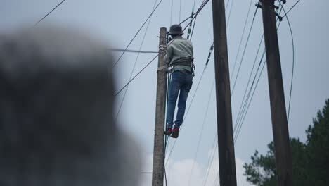 worker repairing or installing power lines on a utility pole