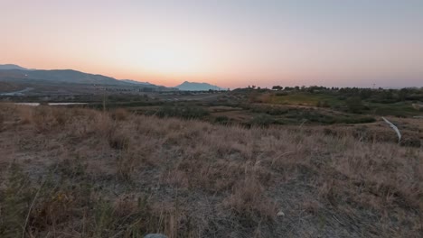 el amanecer dorado brilla sobre un pueblo en las laderas de las montañas - lapso de tiempo