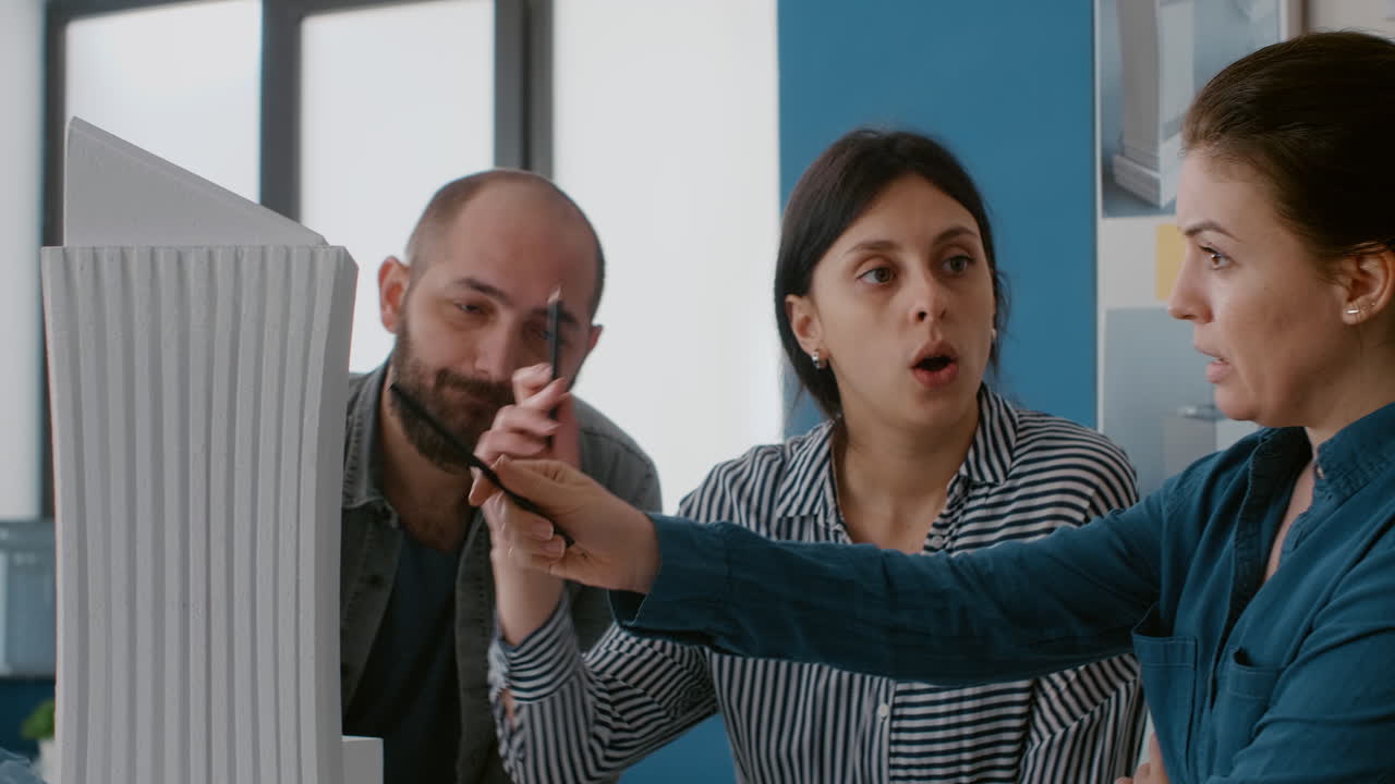 Architectural team discussing a building model in the office