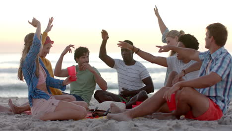 Verschiedene-Freunde-Genießen-Ein-Lebhaftes-Spiel-Am-Strand-Bei-Sonnenuntergang