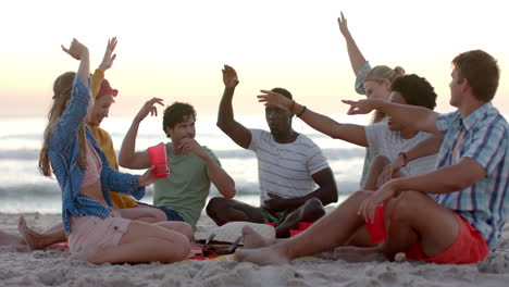 amigos diversos disfrutan de un juego animado en la playa al atardecer