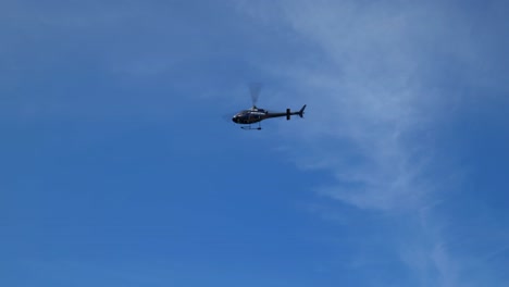 helicóptero negro pasando visto desde el suelo, tiro de seguimiento de dolly