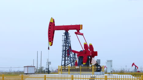 close up industrial construction oilfield kowtow machine rig pumpjack derrick working for crude oil production in a desert landscape