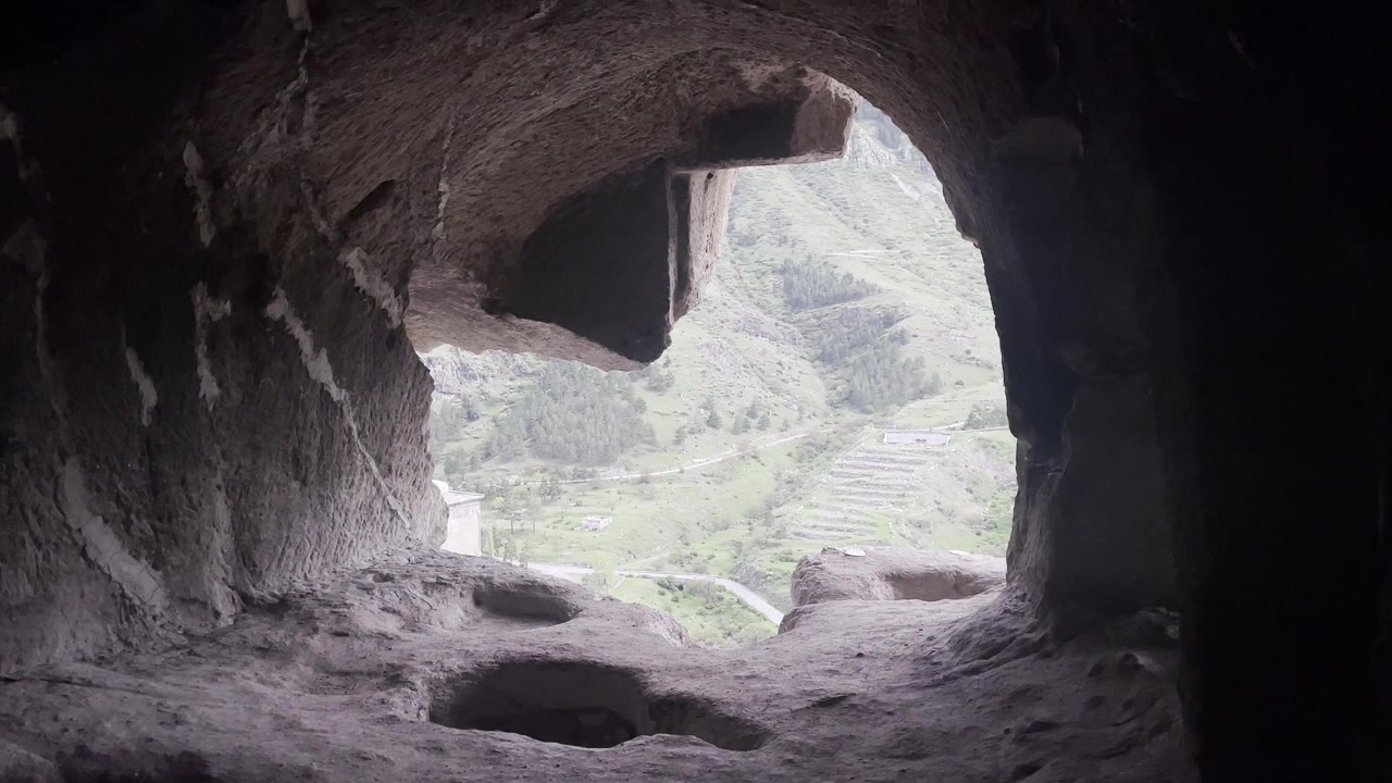 ジョージアの視点：古代ヴァルジア洞窟修道院の内部から緑豊かな山々の風景を見下ろす