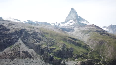 Tilt-up:-drone-aerial-view-on-the-Cervin,-Zermatt-with-a-blue-sky,-Swiss-alps-ressourcing-landscape,-rocky-summit