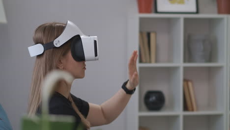 programa educativo interactivo con el uso de hmd-display mujer está usando auriculares vr en el hogar gesticulando con las manos retrato de usuario femenino