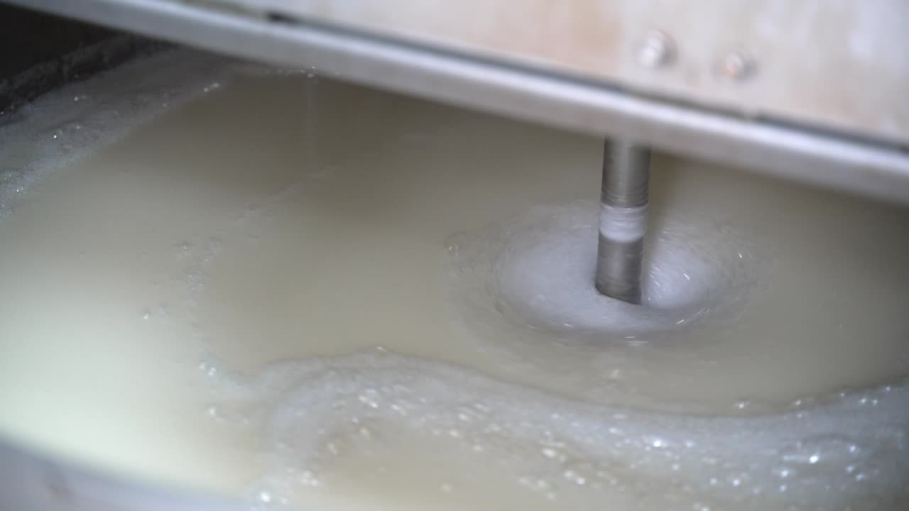 Melted sugar in liquid form to be stirred in a large industrial container
