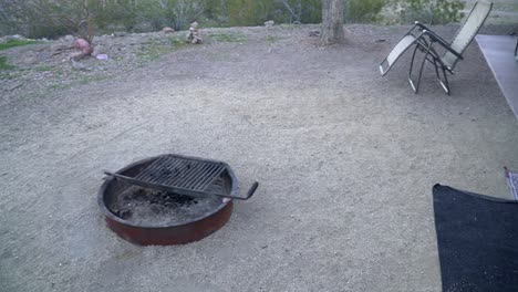 pan of campsite with fire ring,rug and lawn chair