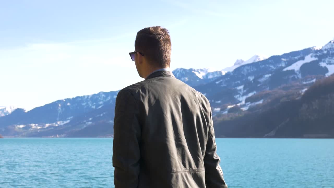 한 젊은 유럽인이 매우 푸른 호수 기슭을 걷고 있다