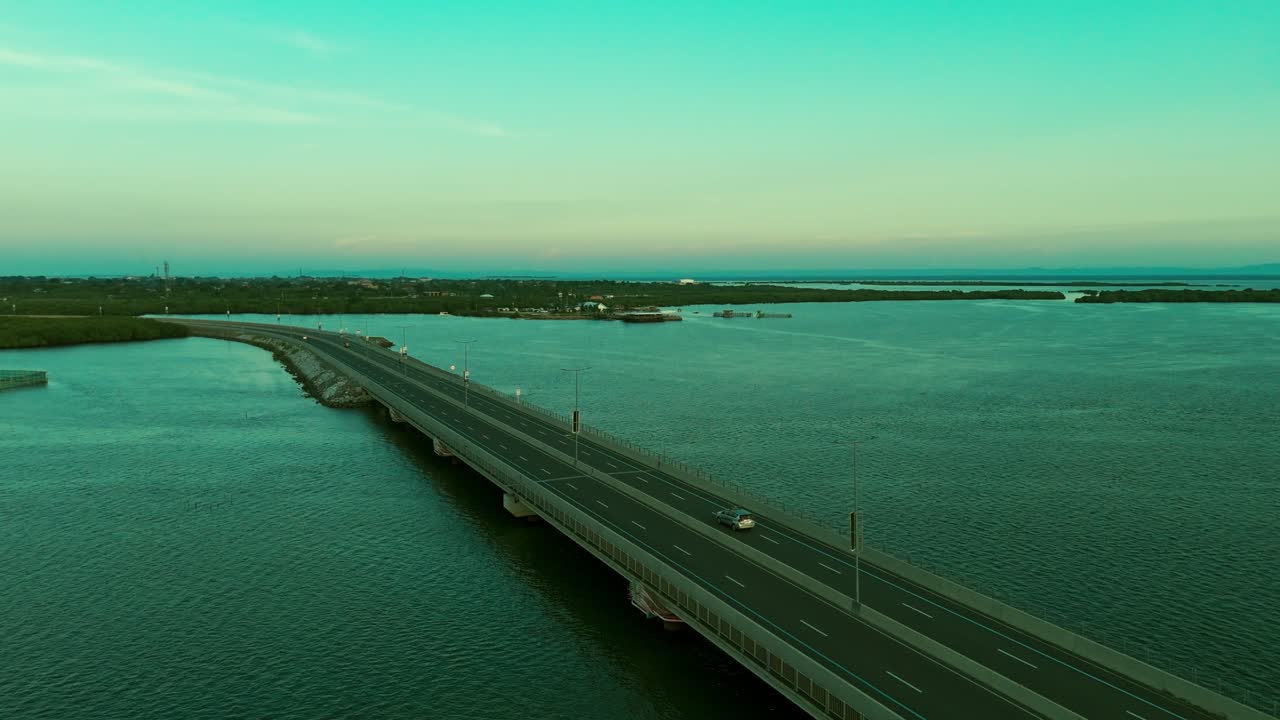 Cinematic 4K drone shot of a long bridge spanning over water with scenic islands and sunset glow. Perfect for travel, infrastructure, transportation, and tourism projects