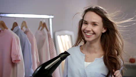 joyful woman singing in hair dryer. emotional woman singing in bathroom