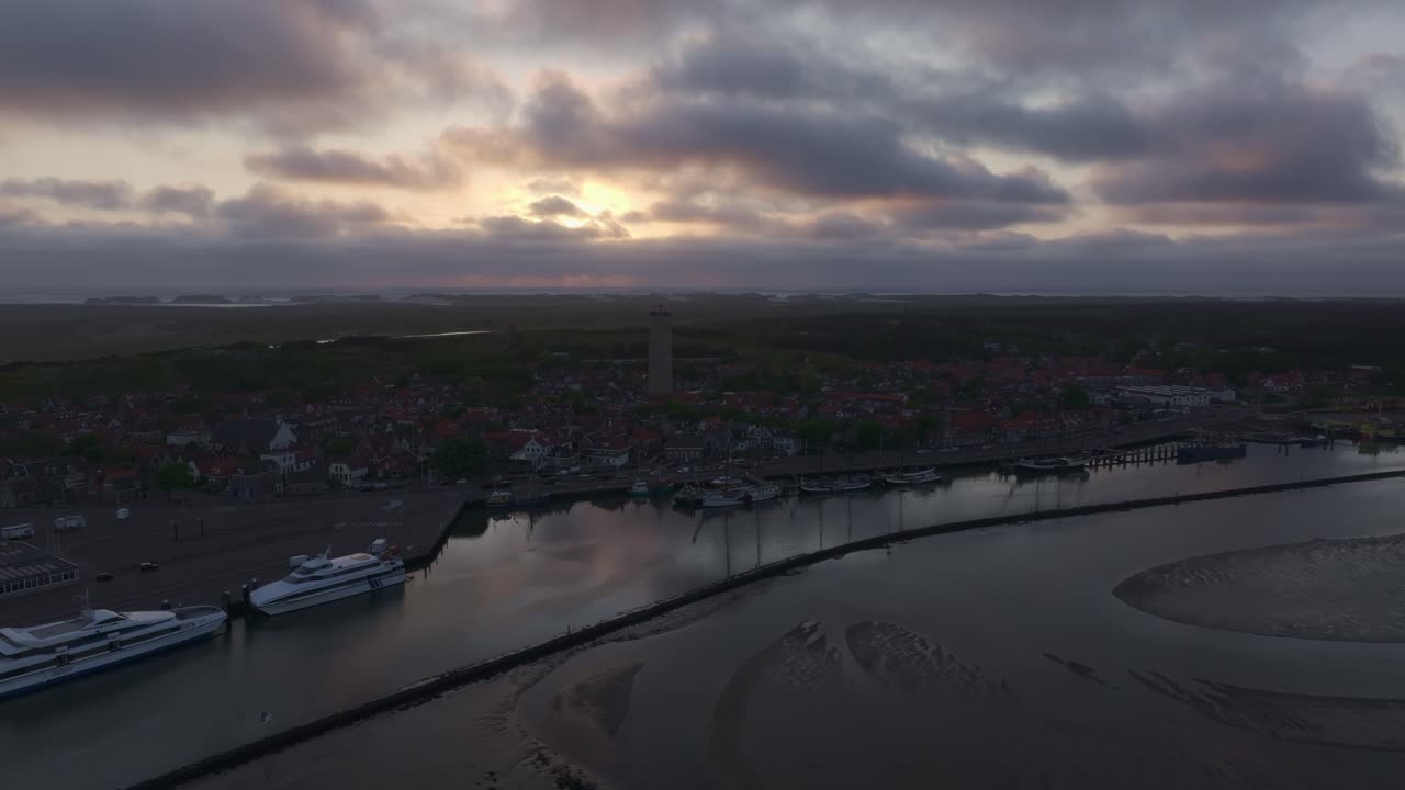 Vue aérienne de Terschelling avec l'île, un ferry, un lever de soleil, présentant un paysage historique atmosphérique aux Pays-Bas.