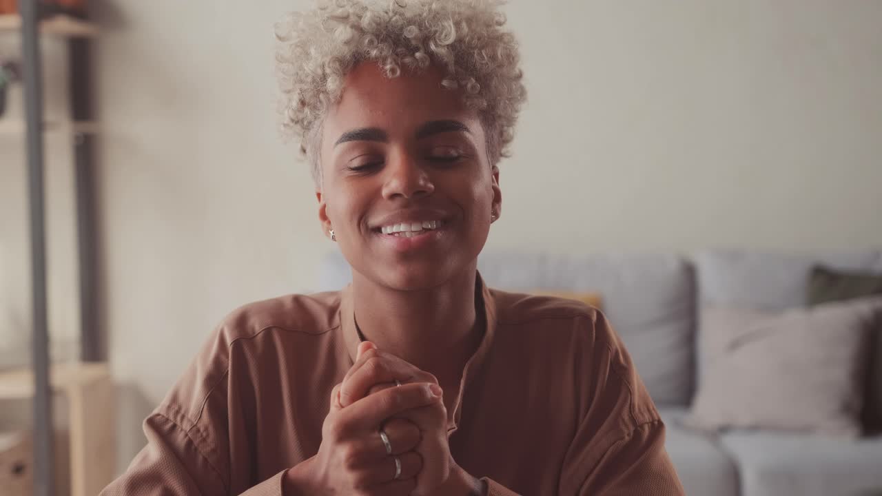 Happy young african woman looking at camera making hello welcoming gesture