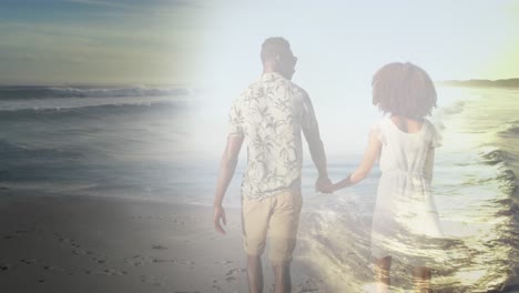 animation of african american couple holding hands at beach over sea
