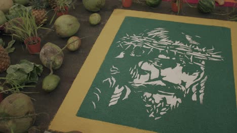 panorámica lenta a través de una obra de arte de jesús con una corona de espinas hecha de arena en guatemala
