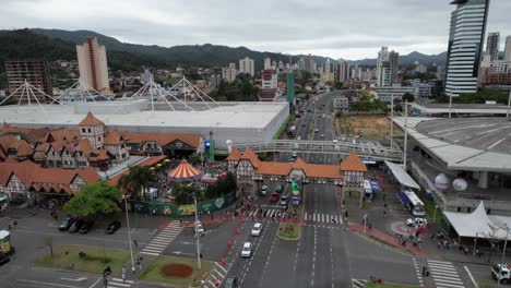 Drone-footage-of-the-Oktoberfest-party-in-Vila-Germânica,-outdoor-area-with-the-amusement-park,-decorations-and-people,-Blumenau,-Santa-Catarina,-Brazil