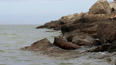 Waves-in-slow-motion-hitting-the-rocky-shore-and-crashing-with-power