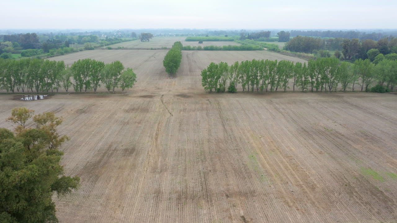 Aerial view of agricultural landscape empty fields soil in preparation for sowing black soy seeds and planting wheat, Drone camera slowly moving backwards