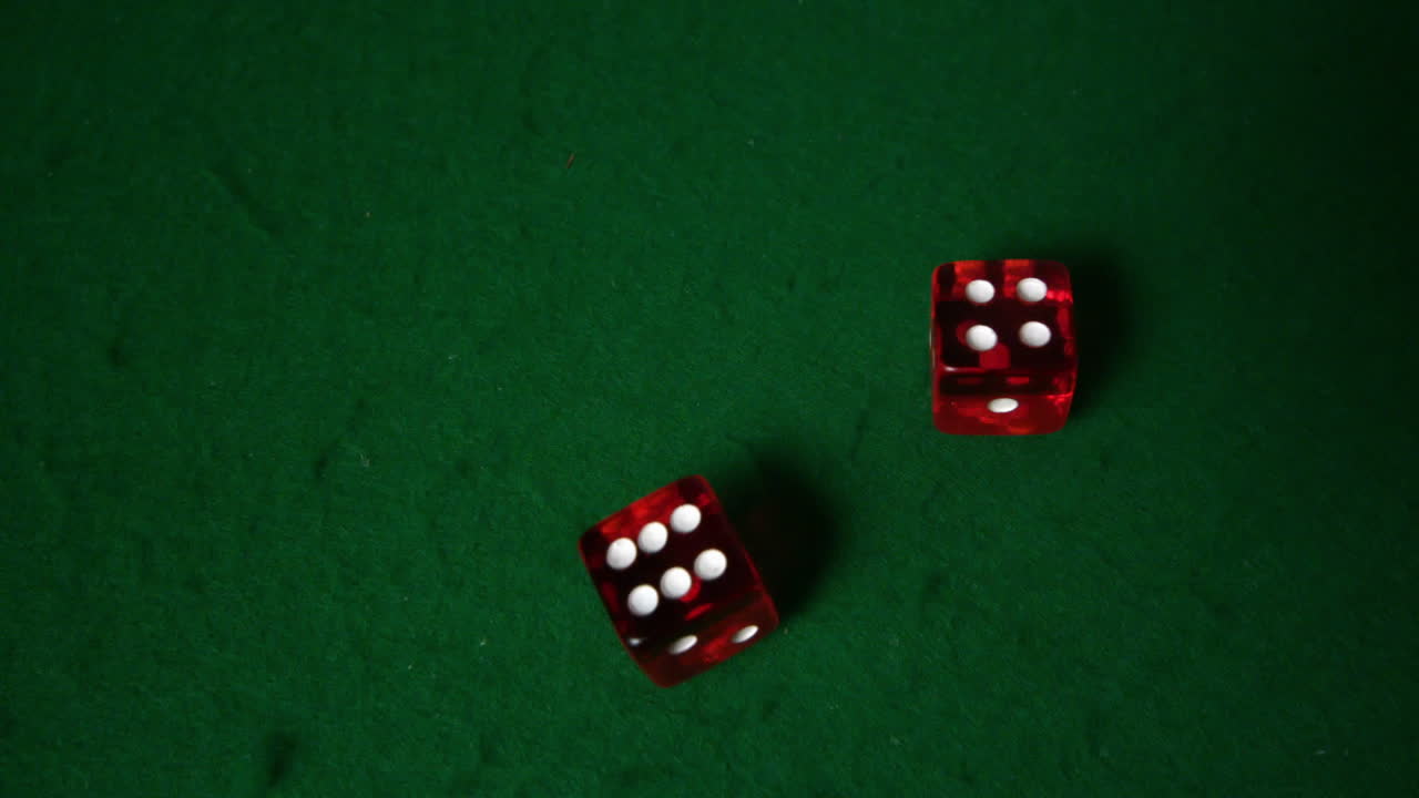 los dados rojos caen en la mesa del casino.