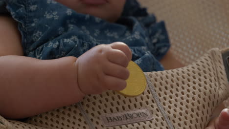 lindo bebé sosteniendo un bitcoin mientras se balancea