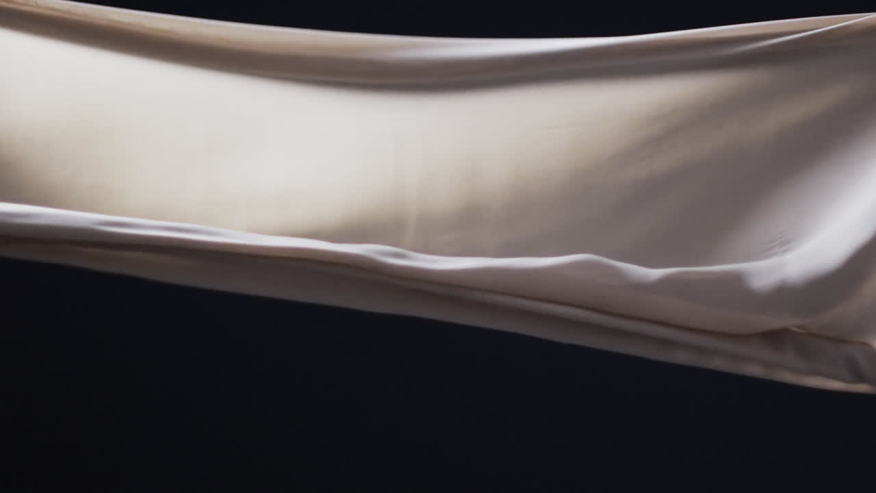 검은색 배경 위에 복사 공간과 함께  ⁇ 색 천을 불어 넣는 애니메이션