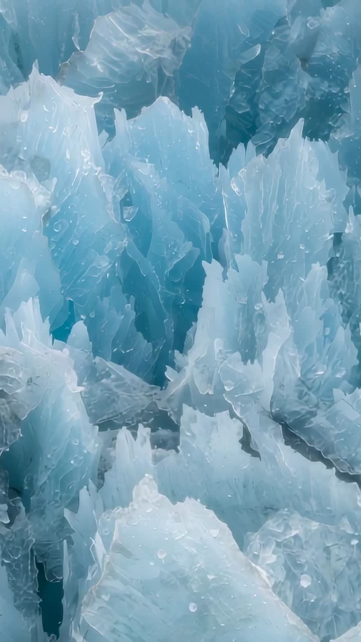 Video verticale: ripresa panoramica con camera che si sposta verso l'interno per rivelare un ghiacciaio, mostrando creste e crepe di ghiaccio blu frastagliato