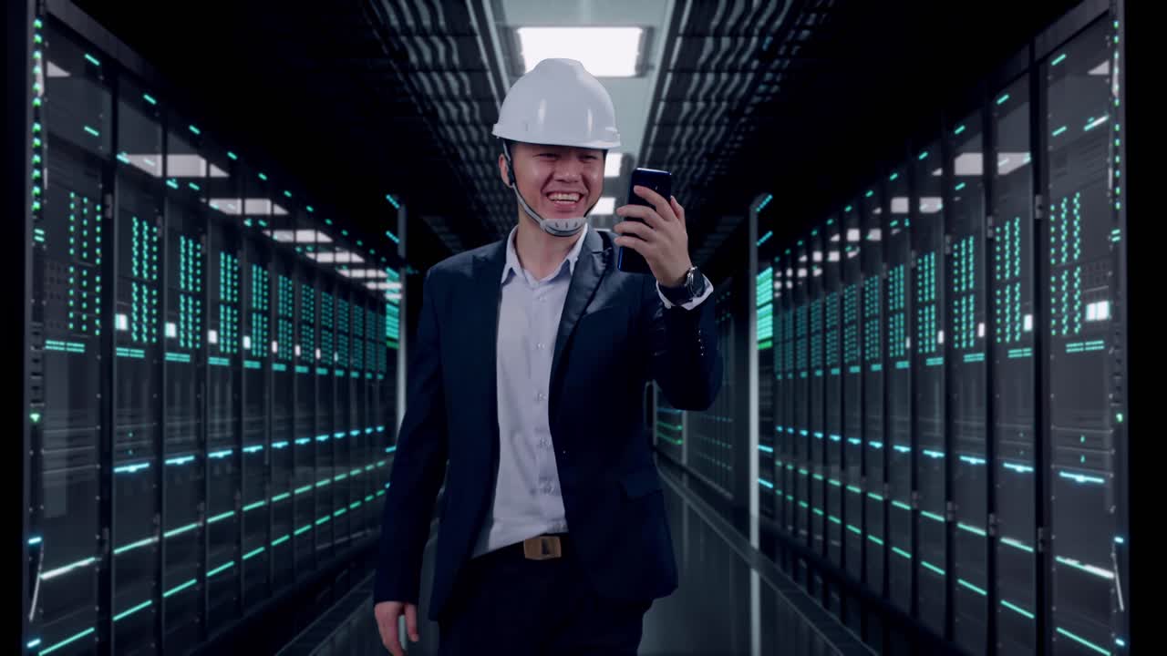 Front View of Asian Businessman Use Smartphone, Video Call While Walking in Server Room Data Center