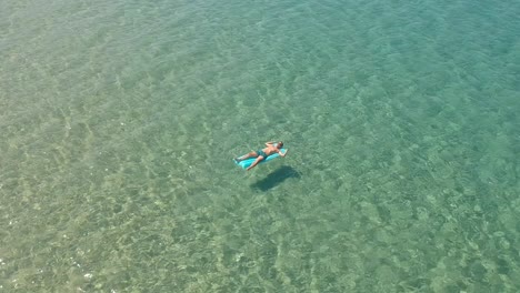 guy flota sobre un colchón inflable en el mar egeo en la ciudad de skala sotiros grecia