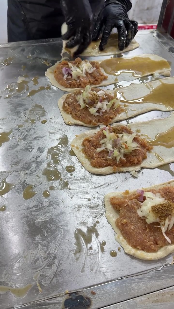Chef Preparing Traditional Meat-Filled Flatbreads on Metal Counter