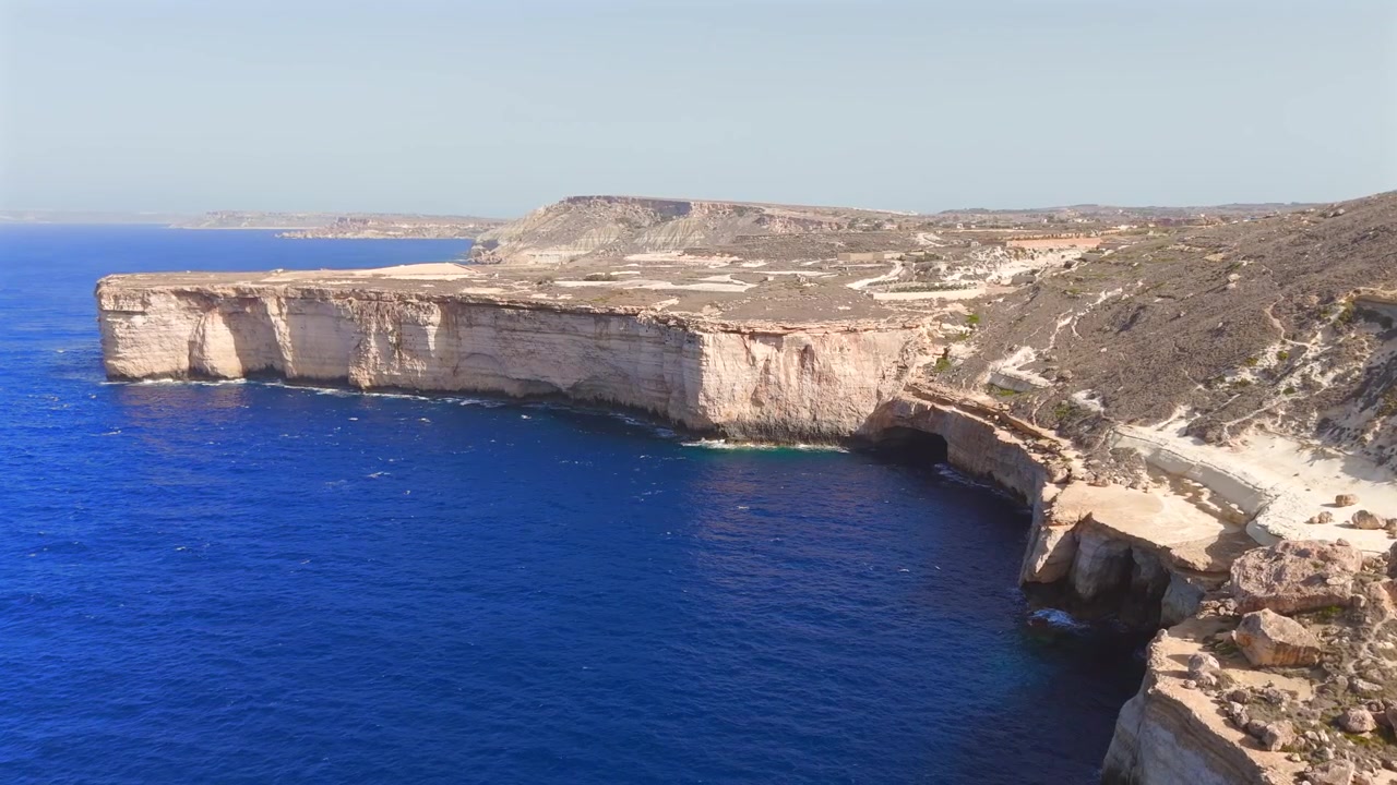 Scopri la bellezza mozzafiato delle scogliere oceaniche di Malta dalla prospettiva di un drone, rivelando formazioni rocciose straordinarie e le tonalità ipnotizzanti del Mar Mediterraneo sottostante