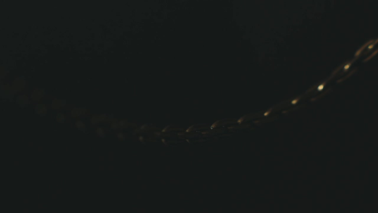 검정색 배경의 금 사슬 목걸이에 빛나는 빛을 엿볼 수 있습니다.