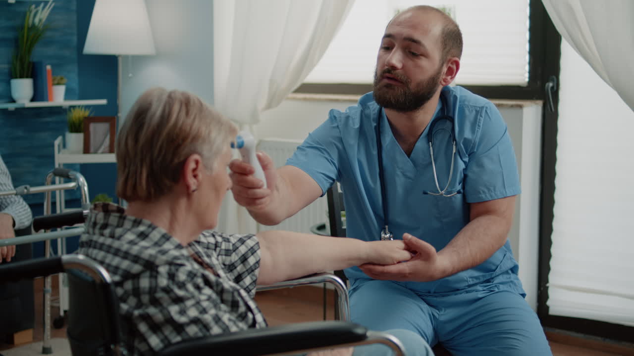 Medical assistant using thermometer on old woman