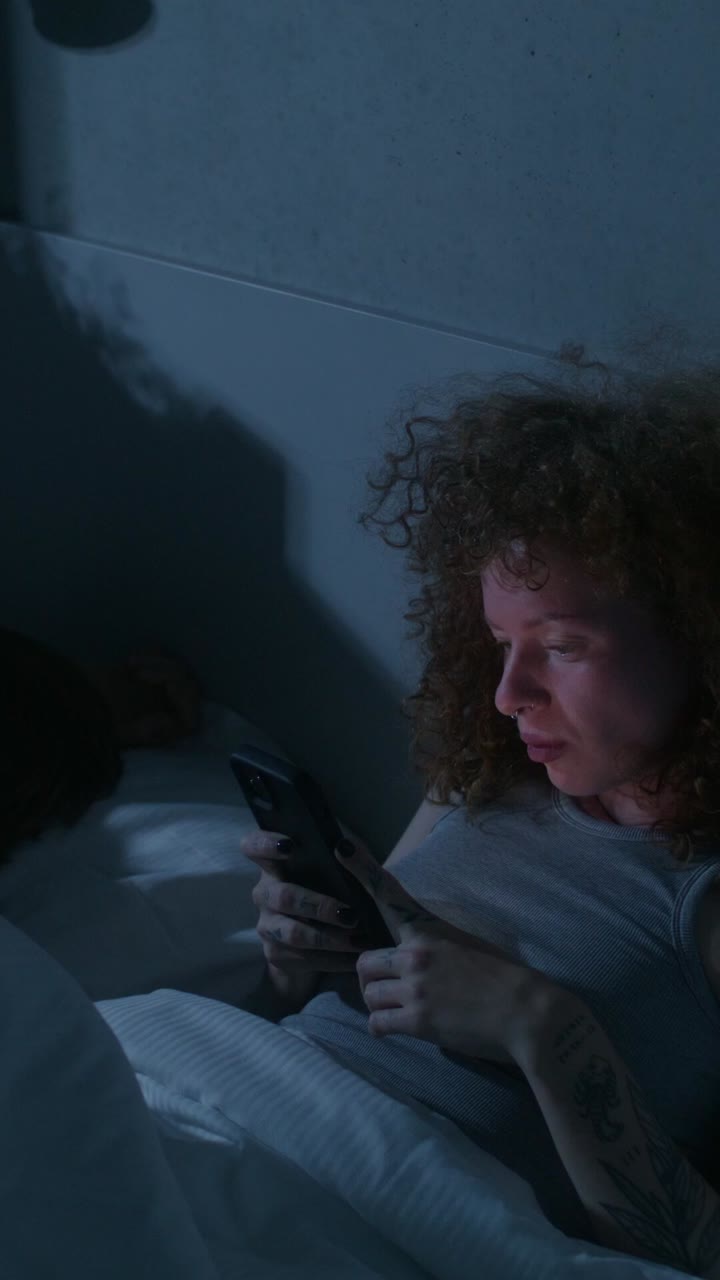 mujer usando el teléfono en la cama por la noche