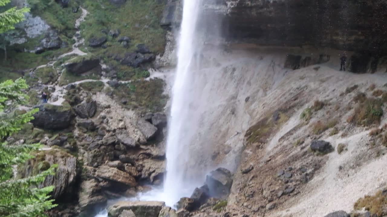 The beautiful waterfall of Pericnik Waterfall in Slovenia. Man standing behind the waterfall in slow motion