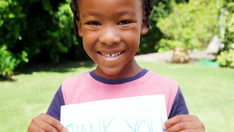 Little-boy-holding-a-piece-of-paper-with-the-message-thank-you