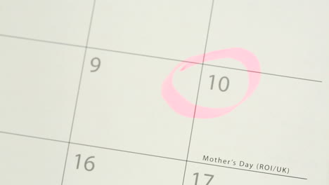 hombre rodeando el día de la madre en el calendario y colocando el tulipán