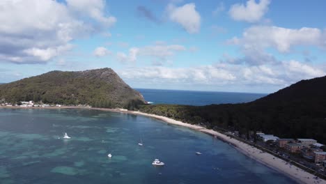 Vista-Aérea-De-Una-Costa-Con-Barcos,-Playa-De-Arena-Y-Una-Ciudad-Costera