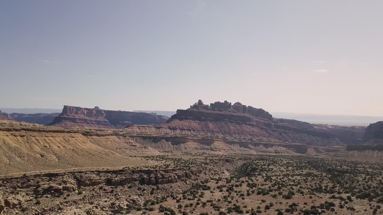 невероятно красивые кадры с беспилотника, летящего вниз со скалы меса над пустынной долиной, кустами и пейзажем в каньоне черного дракона в грин-ривер, штат юта, сша