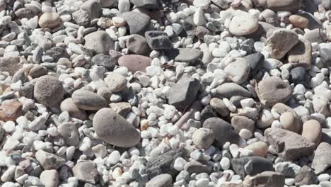 dropping beautiful stones on other stones, static close up view