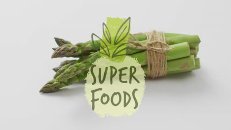 super foods text animation over asparagus bundle tied with twine