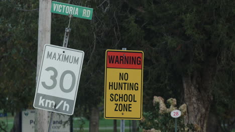 Trees-blowing-behind-a-no-hunting-and-speed-limit-sign