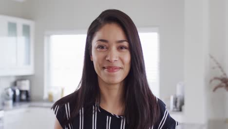 retrato de una feliz mujer biracial mirando a la cámara y sonriendo, cámara lenta