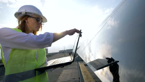 lady solar engineer is closing her laptop and glancing into the camera