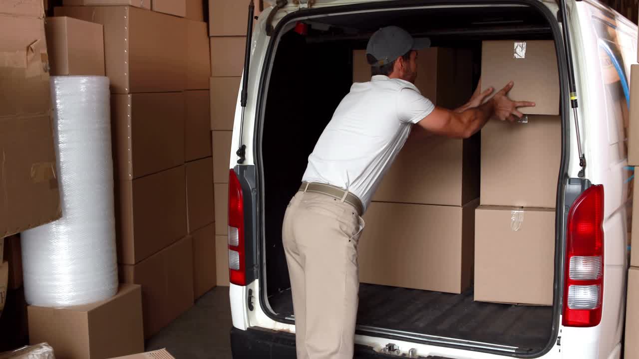 Reaching to close box, logistics worker loading parcels into van under scrolling code overlay