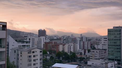 paisaje urbano de quito con el horizonte bajo un cielo naranja durante la puesta de sol en ecuador