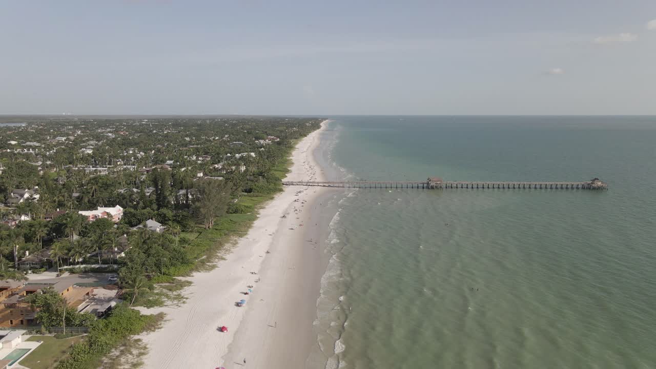 muelle de pesca en la costa del mar tropical sobresale de la playa de arena poco profunda