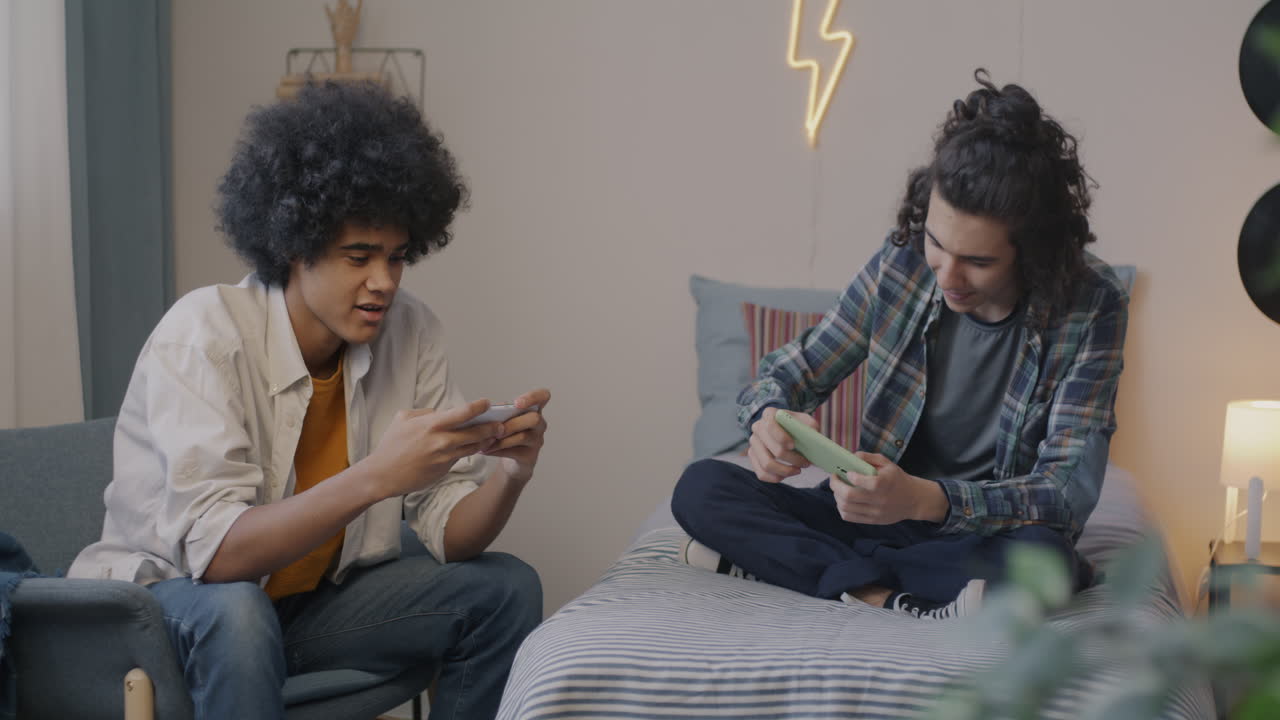 Teen Boys Playing Games on Smartphones in a Bedroom