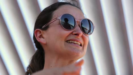 casual happy smiling woman wearing round sunglasses candid laugh