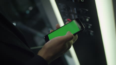 hombre tocando el teléfono inteligente móvil con pantalla verde de la tecla de croma